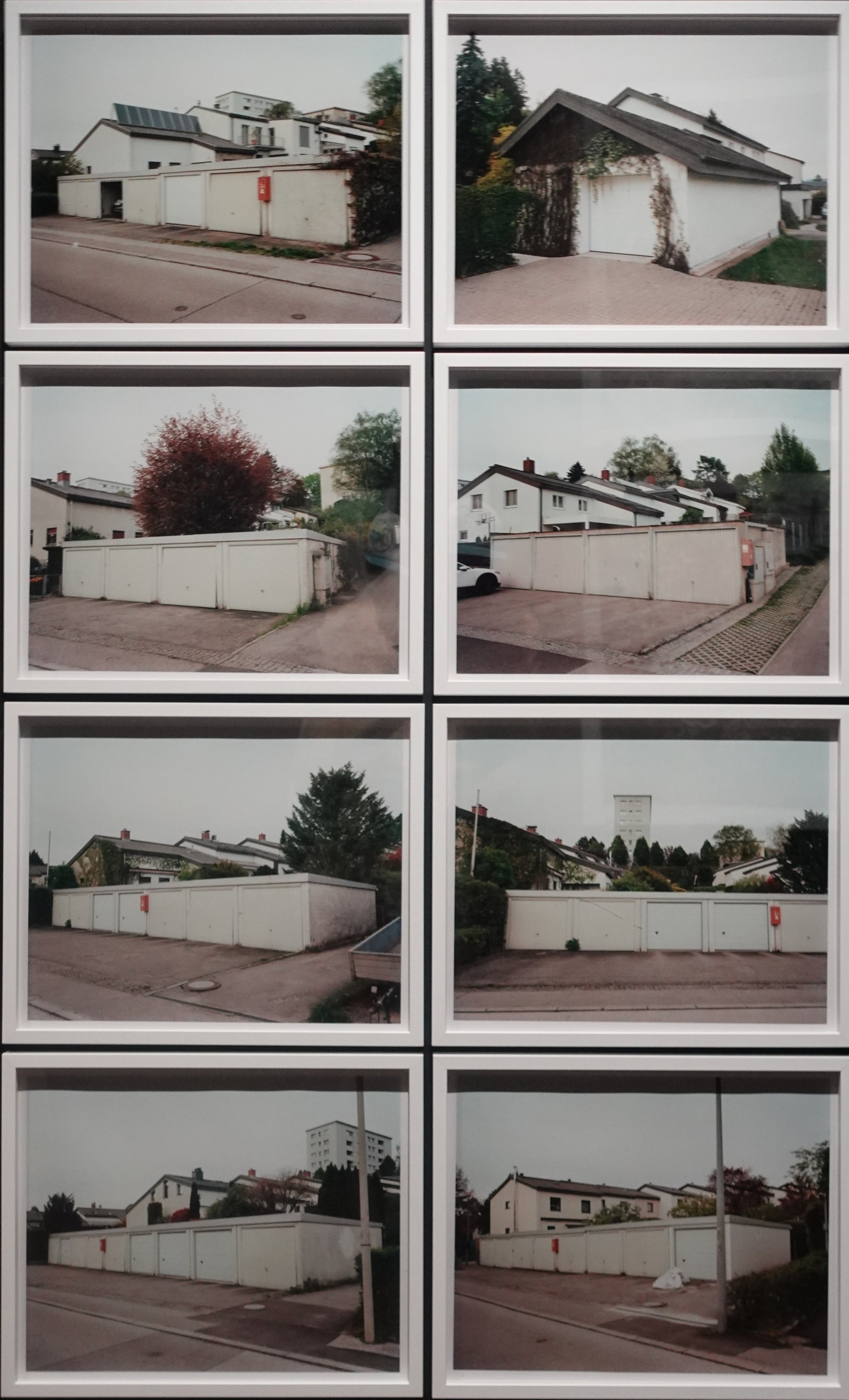 Acht Polaroid-Fotos von weißen Garagen in Wohngebieten, verschiedene Perspektiven und Tageszeiten.